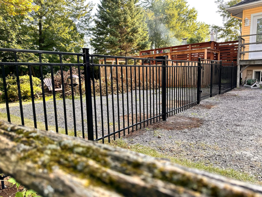 Clôture en aluminium ornemental noir installée dans une cour résidentielle